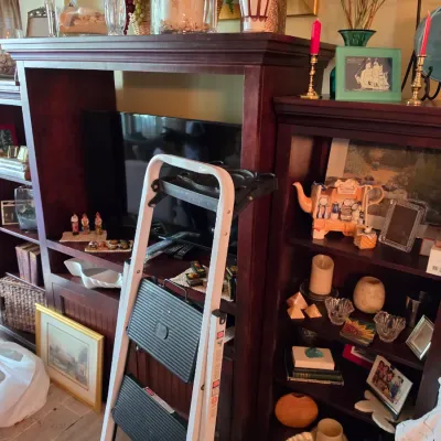 Sale Photo Thumbnail #205: Large mahogany-finished three-piece entertainment wall unit featuring a central TV opening, side shelving units, and displayed home decor items.