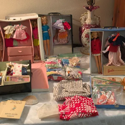 Sale Photo Thumbnail #127: Vintage 1960s Barbie and Tammy doll collection, including carrying cases, various outfit sets, accessories in plastic bags, and Beatrix Potter books.