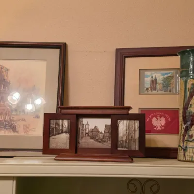 Sale Photo Thumbnail #228: Collection of framed artwork and decor including watercolor prints, a wooden multi-opening photo frame, and a tall glazed studio pottery vase.