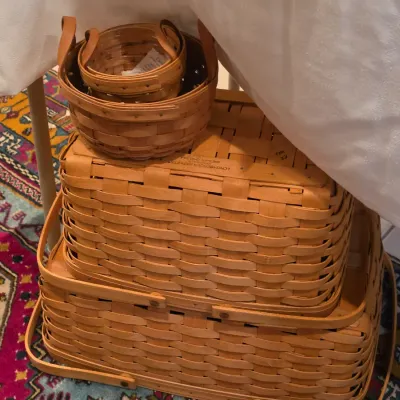 Sale Photo Thumbnail #63: Stack of vintage Longaberger woven wood veneer baskets in various sizes, including a picnic basket with a lid.