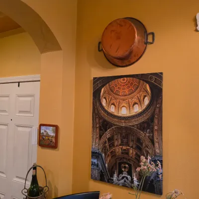Sale Photo Thumbnail #50: Large canvas wall art depicting a cathedral interior with an ornate dome, mounted below a decorative copper pot on a yellow wall.