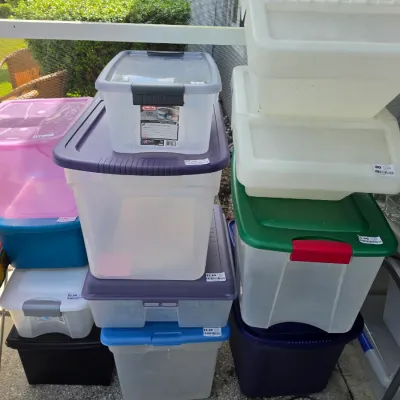 Sale Photo Thumbnail #340: Assorted plastic storage bins and totes in various colors, sizes, and styles with price tags.