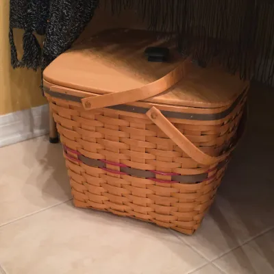 Sale Photo Thumbnail #49: Large Longaberger woven wood picnic basket with a fitted lid, double swing handles, and pink accent weave.