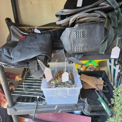 Sale Photo Thumbnail #274: Black plastic utility shelving unit holding various duffel bags, a clear bin of holiday ornaments, and miscellaneous household items.