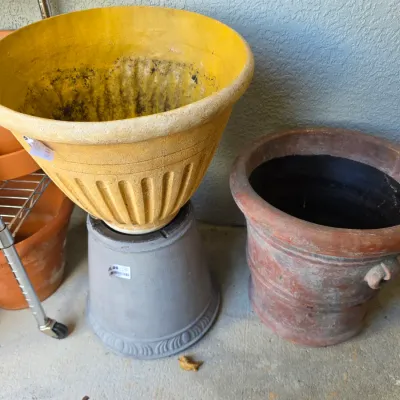 Sale Photo Thumbnail #346: Selection of large outdoor planters, including a bright yellow urn style pot on a base and a weathered terracotta planter.