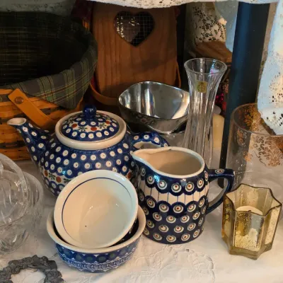 Sale Photo Thumbnail #81: Collection of Polish pottery tea items featuring iconic blue peacock eye patterns, surrounded by cut crystal glass bowls, mercury glass votive holders, and a Longaberger basket.