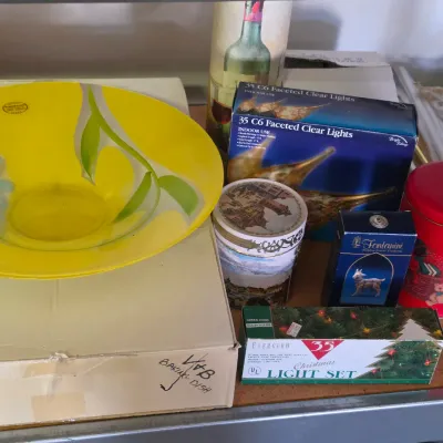 Sale Photo Thumbnail #291: Selection of vintage household items and Christmas decorations, including a bright yellow glass bowl, boxed string light sets, and a Fontanini nativity figurine.