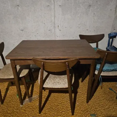 Sale Photo Thumbnail #16: Mid-century modern dining set featuring a wooden table and four matching chairs with curved backrests and upholstered seats.