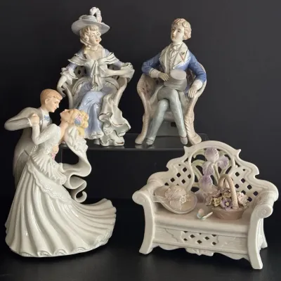 Collection of glazed porcelain figurines, including Victorian-style aristocratic couples, a dancing bride and groom, and a decorative...