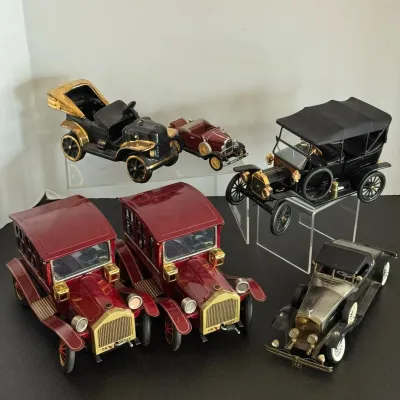 Collection of six vintage die-cast model antique cars, including two matching maroon sedans, a Ford Model T, and various classic roadsters.