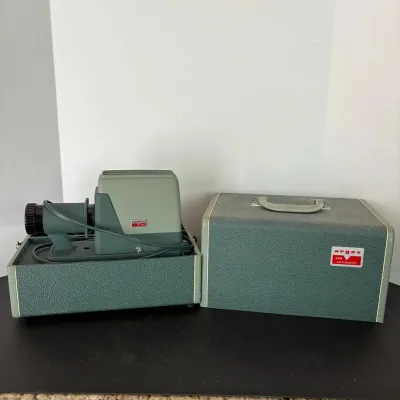 Sale Photo Thumbnail #107: Vintage Argus 300 Automatic 35mm slide projector in original teal carrying case, circa 1950s-1960s.