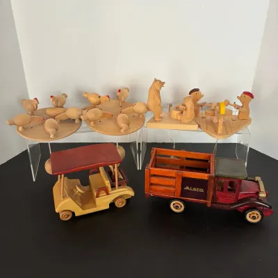 Collection of vintage carved wooden toys, including mechanical action pecking chicken platforms, animated figures, a golf cart, and an...