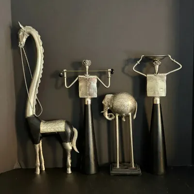 Collection of four metal and wood African or Asian-inspired stylized decorative sculptures, including figures, an elephant, and a...
