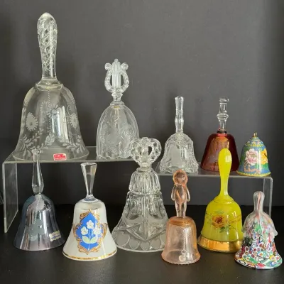 Collection of ten vintage glass and porcelain decorative bells, featuring clear cut glass, hand-painted floral motifs, and colorful art...