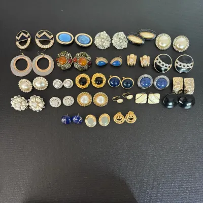Collection of vintage costume clip-on and stud earrings featuring faux pearls, enamel details, and cabochon accents.