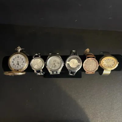 Collection of six modern wristwatches and pocket watches, including Citizen Eco-Drive, Geneva, and St. Moritz brands, displayed on a...