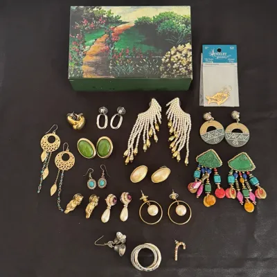 Collection of fashion jewelry featuring statement drop earrings, faux pearl fringe, turquoise and green stone accents, alongside a floral...
