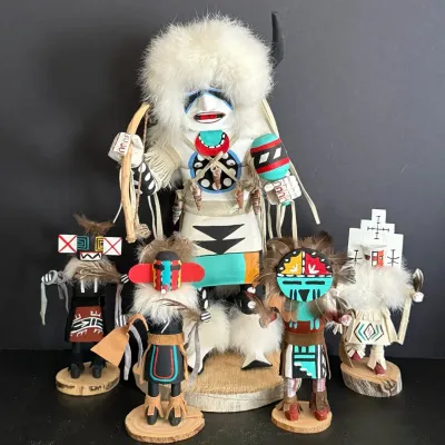 Collection of five Hopi-style hand-carved wooden Kachina dolls featuring elaborate traditional paint, fur, and feather adornments.