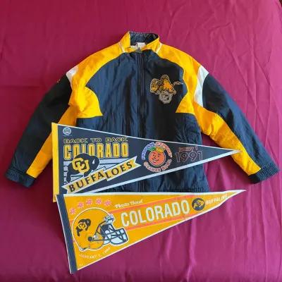 Vintage Colorado Buffaloes zip-up windbreaker jacket paired with two commemorative bowl game felt pennants from the 1991 Orange Bowl and...