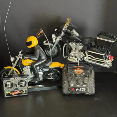 Two vintage radio-controlled Harley-Davidson motorcycle toys, including a Tyco R/C model with rider figure and a New Bright V-Rod model,...
