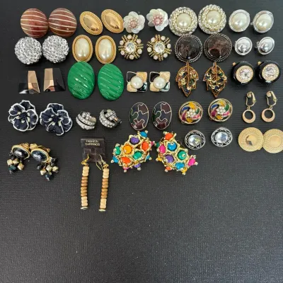 Collection of vintage clip-on and pierced costume earrings in various retro styles, colors, and metal finishes.
