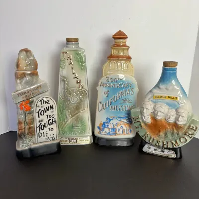 Collection of four vintage Jim Beam ceramic decanters, including Tombstone Arizona, Thailand, California Missions, and Mount Rushmore...