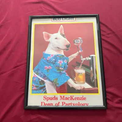 Framed vintage 1980s Bud Light poster featuring Spuds MacKenzie, "Dean of Partyology", housed in a black frame.