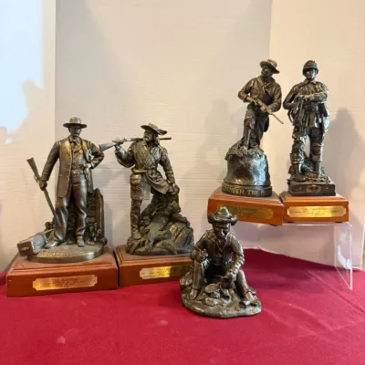 Collection of five bronze-finish Western and military themed statues mounted on wooden bases, featuring detailed historical figures.