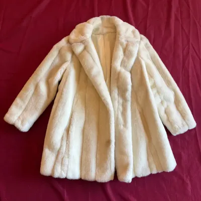 Vintage off-white faux fur stroller coat with wide notched lapels and vertical paneling.