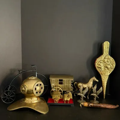 Collection of vintage brass decorative items, including a miniature diver's helmet, carriage figurines, horse and eagle statues,...