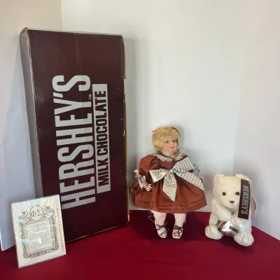 Collectible Hershey's themed blonde porcelain doll with original box, certificate of authenticity, and a plush Hershey's polar...