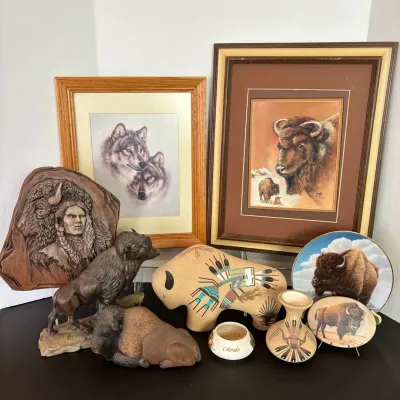 Sale Photo Thumbnail #101: Collection of Western and Native American-themed decor, including bison and wolf framed prints, bison figurines, ceramic art pottery, and relief carvings.