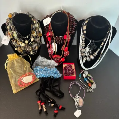 Collection of statement necklaces and beaded jewelry, featuring chunky multi-strand designs, glass accents, and silver-tone pendants...