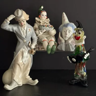 Collection of vintage clown figurines, including glaze-finished porcelain figures and a colorful Murano-style art glass clown playing a...