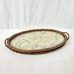 Sale Photo Thumbnail #209: Vintage oval woven wicker serving tray featuring a glass base with a illustrated bird motif.