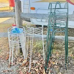 Sale Photo Thumbnail #82: Collection of vintage wire metal plant stands in white and green finishes, stacked outdoors.
