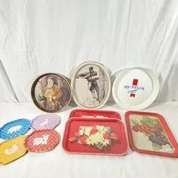 Sale Photo Thumbnail #158: Collection of vintage decorative metal serving trays and coasters, including round illustrated trays and rectangular floral designs.