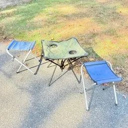Sale Photo Thumbnail #46: Portable camping set featuring a green fabric folding table with cup holders and two blue metal folding stools.