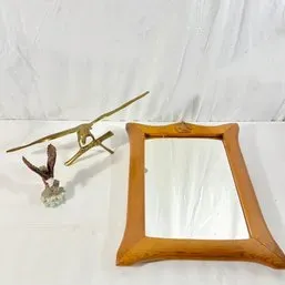 Sale Photo Thumbnail #114: Vintage wood-framed mirror alongside a brass flying eagle sculpture and a painted eagle figurine.