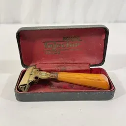Sale Photo Thumbnail #151: Vintage Schick Injector razor with a butterscotch Bakelite handle, presented in its original velvet-lined hard case.