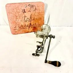 Sale Photo Thumbnail #205: Vintage metal hand-crank meat grinder paired with a 'Kitchen Keepers' vintage cutting board.