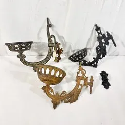 Sale Photo Thumbnail #125: Collection of vintage cast iron and metal swiveling plant hangers and mounting brackets featuring ornate filigree and basket-style holders.