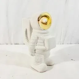 Sale Photo Thumbnail #241: Novelty white ceramic astronaut planter or vase featuring a metallic gold reflective visor.