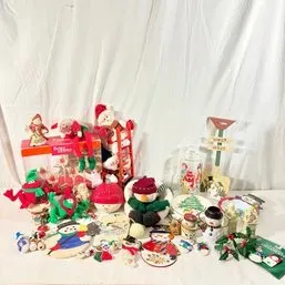 Sale Photo Thumbnail #61: Collection of Christmas and winter holiday decor, featuring plush snowmen, elf figures, decorative plates, and ornaments.