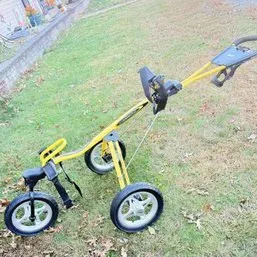 Sale Photo Thumbnail #53: Yellow Sun Mountain Speed Cart collapsible three-wheel golf push cart, featuring a padded handle, score card holder, and large spoked wheels.