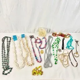 Sale Photo Thumbnail #182: Assortment of vintage costume jewelry necklaces including faux pearls, beaded strands, shell necklaces, and a magnifying glass pendant.