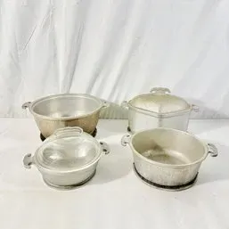 Sale Photo Thumbnail #215: Collection of four vintage aluminum cookware pieces, including Dutch ovens and covered casserole dishes, showing some age-appropriate wear.