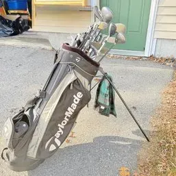 Sale Photo Thumbnail #246: TaylorMade stand golf bag loaded with an assortment of golf clubs and accessories.