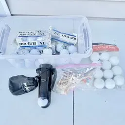 Sale Photo Thumbnail #14: Collection of golf accessories including plastic storage tote filled with Top-Flite XL golf balls, additional bagged golf balls, wooden tees, and a ball retriever device.