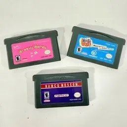Sale Photo Thumbnail #137: Trio of Nintendo Game Boy Advance video game cartridges, including Barbie Groovy Games, Hamtaro: Ham-Ham Games, and Namco Museum.